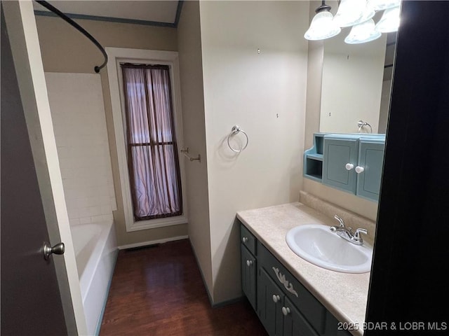 bathroom with  shower combination, baseboards, wood finished floors, and vanity