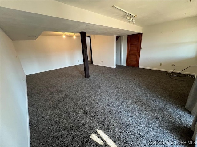 finished basement featuring dark colored carpet, track lighting, and baseboards