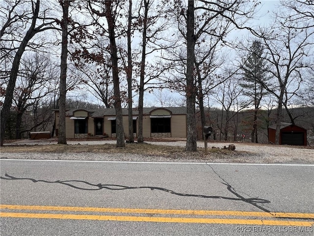 view of front facade with roof with shingles and an outbuilding