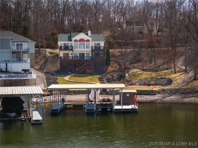 dock area with a water view, a yard, boat lift, and stairs