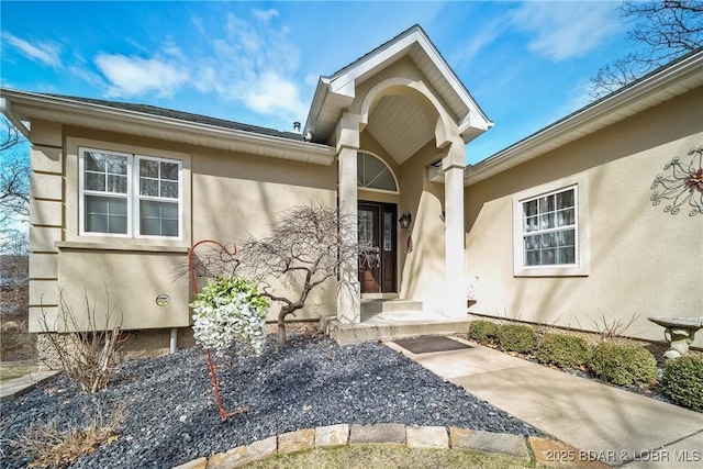 entrance to property featuring stucco siding