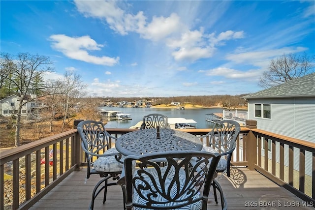 wooden deck with outdoor dining area and a water view