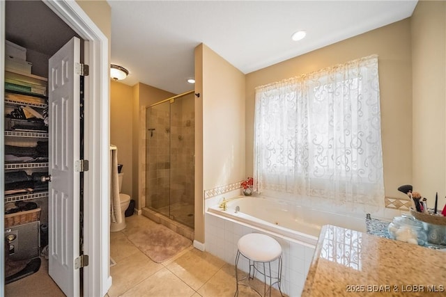 full bath featuring a bath, a shower stall, toilet, and tile patterned floors