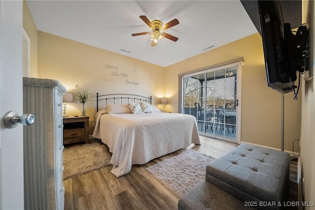 bedroom with a ceiling fan, access to outside, visible vents, and wood finished floors