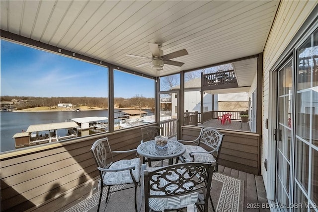 sunroom with wooden ceiling, a water view, and a ceiling fan