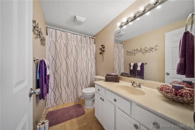 bathroom featuring toilet, tile patterned floors, a textured ceiling, and vanity