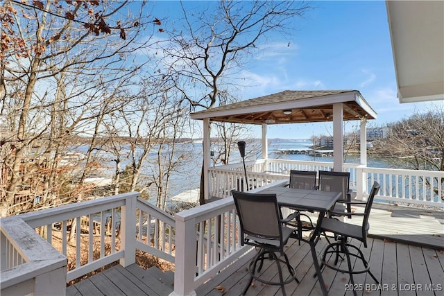 deck featuring a gazebo, outdoor dining space, and a water view