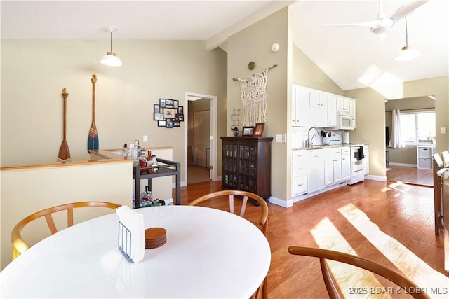 dining space featuring baseboards, high vaulted ceiling, beamed ceiling, and light wood-style floors