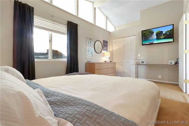 bedroom with high vaulted ceiling, multiple windows, a closet, and light colored carpet