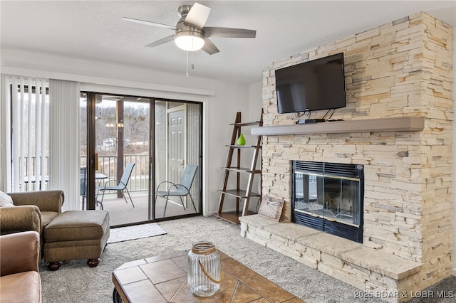 carpeted living room featuring ceiling fan, a fireplace, and a textured ceiling