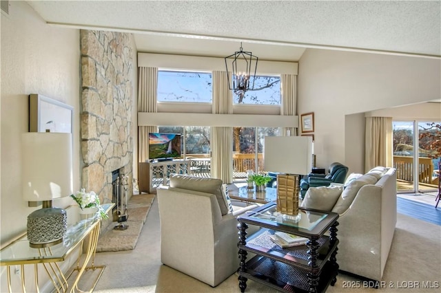 carpeted living area with a textured ceiling, a stone fireplace, and a healthy amount of sunlight