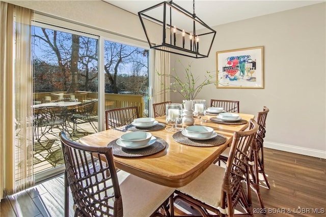 dining area featuring plenty of natural light, wood finished floors, an inviting chandelier, and baseboards