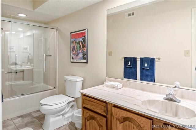 full bathroom featuring shower / bath combination with glass door, visible vents, toilet, vanity, and tile patterned flooring