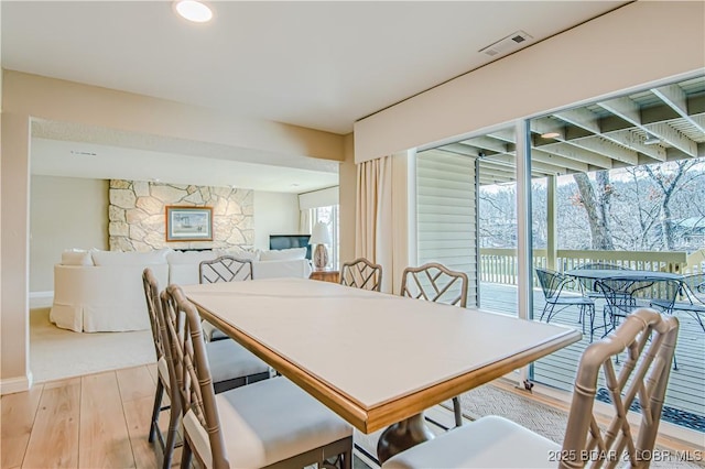 dining room featuring light wood-style floors, visible vents, and baseboards