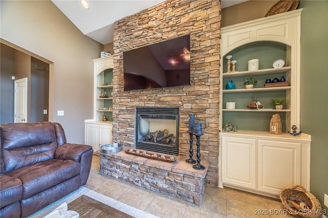 living area with light tile patterned floors, a stone fireplace, lofted ceiling, and built in features