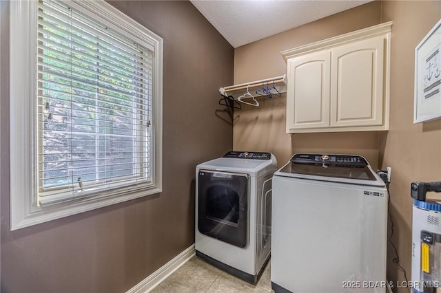 laundry room with cabinet space, independent washer and dryer, baseboards, and light tile patterned flooring