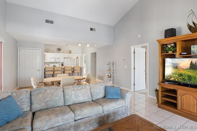 living room featuring light tile patterned floors, visible vents, and high vaulted ceiling