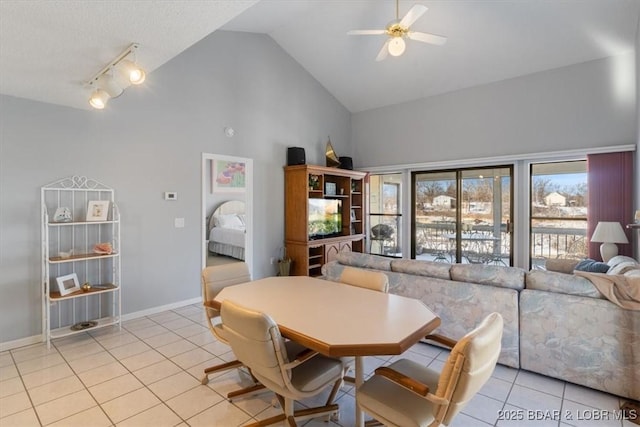 dining area featuring track lighting, light tile patterned floors, ceiling fan, and high vaulted ceiling