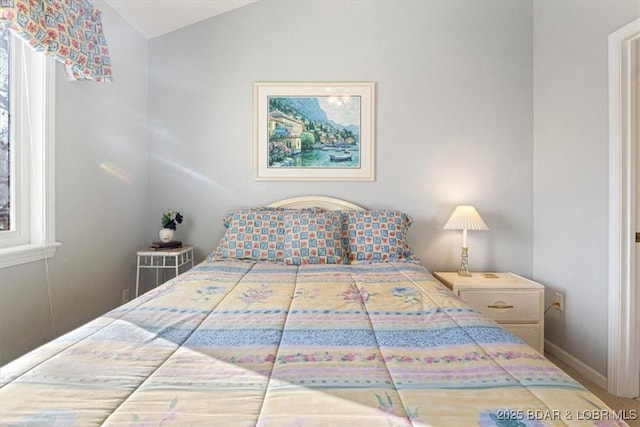 bedroom featuring vaulted ceiling and baseboards