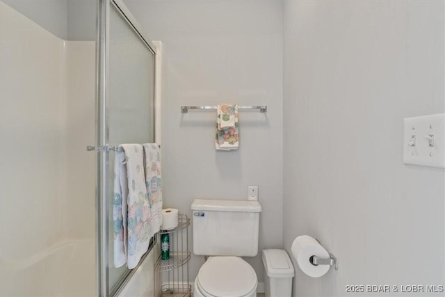 full bath with baseboards, a shower stall, and toilet