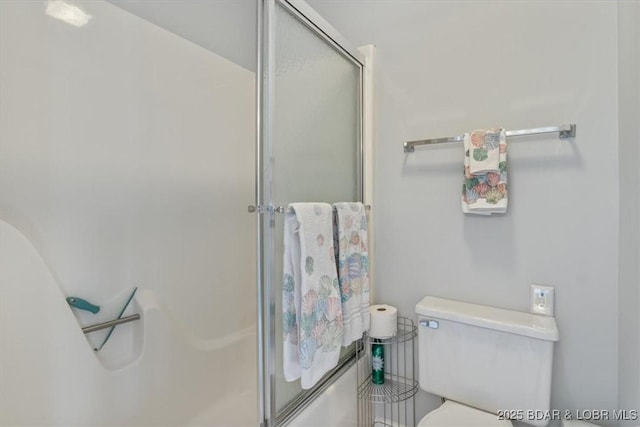 bathroom with a shower stall and toilet