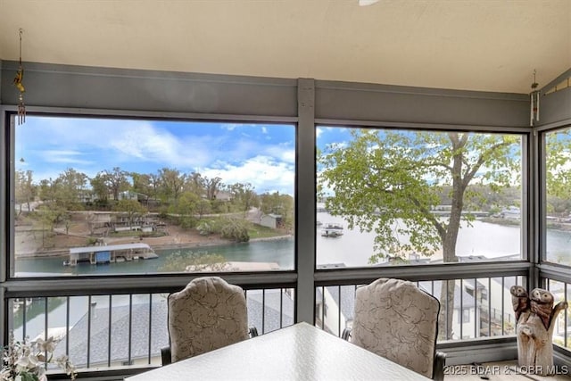 sunroom / solarium featuring a water view