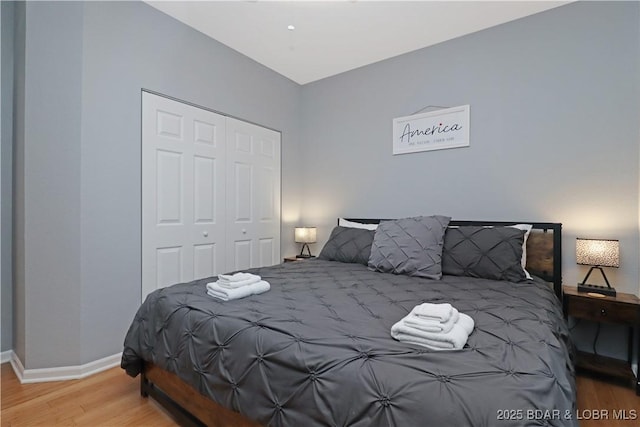 bedroom with a closet, baseboards, and wood finished floors