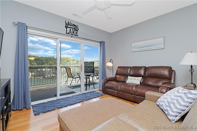 living area featuring light wood-style floors, ceiling fan, and visible vents