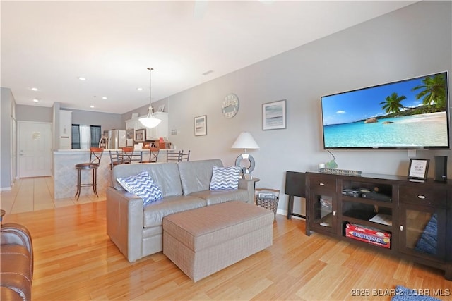 living room with light wood finished floors, baseboards, and recessed lighting