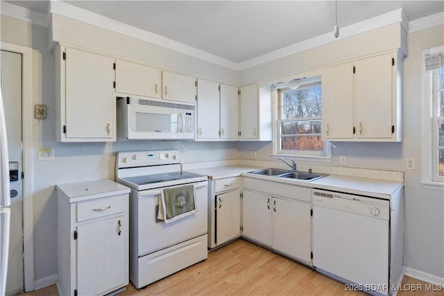 kitchen featuring light wood finished floors, light countertops, ornamental molding, a sink, and white appliances