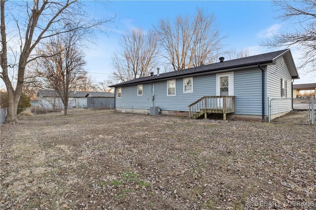 rear view of house with cooling unit and fence