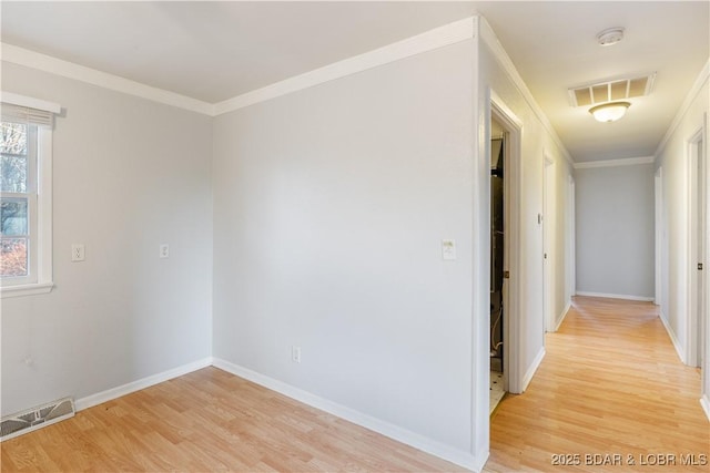 interior space with ornamental molding, light wood-type flooring, and visible vents