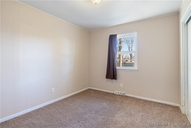 spare room with baseboards, visible vents, and carpet flooring