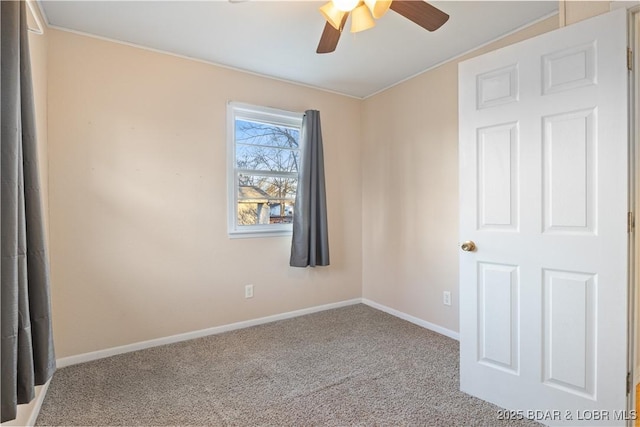 carpeted spare room with baseboards and a ceiling fan