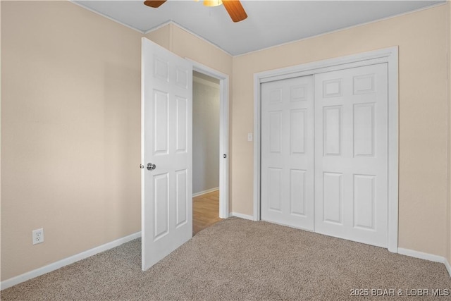 unfurnished bedroom with carpet floors, a closet, and baseboards