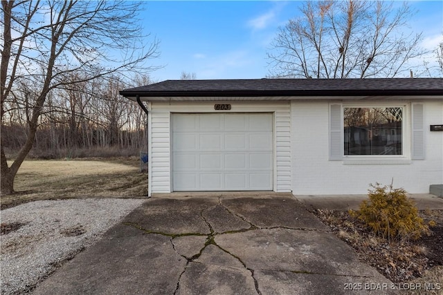 garage featuring concrete driveway