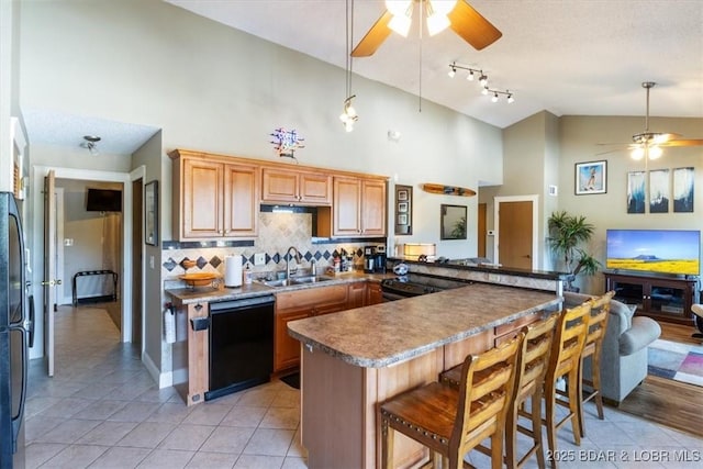 kitchen featuring dishwasher, ceiling fan, backsplash, a sink, and light tile patterned flooring