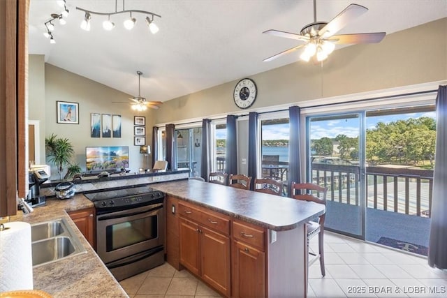 kitchen with lofted ceiling, electric stove, brown cabinets, and a kitchen breakfast bar