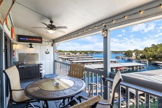 balcony with a water view and a ceiling fan