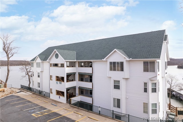 view of property with uncovered parking and a water view