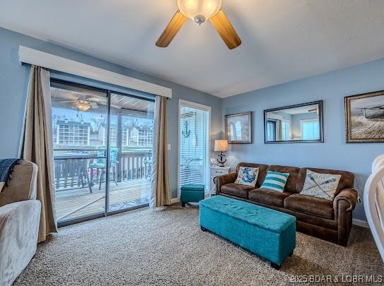 living area with carpet floors and ceiling fan