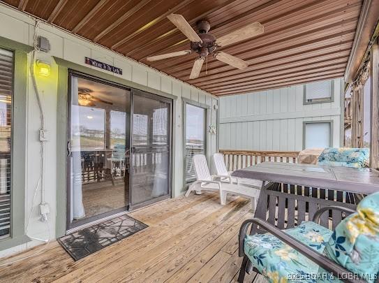 sunroom / solarium with a ceiling fan and wooden ceiling