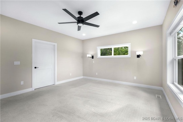 spare room featuring baseboards, light colored carpet, and a healthy amount of sunlight