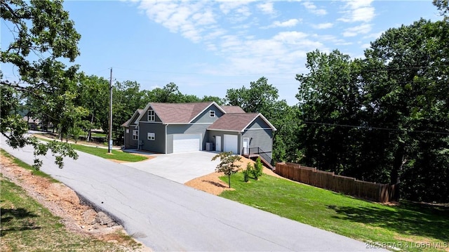 view of front facade featuring a garage, a front lawn, and fence