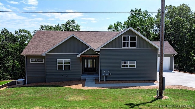 craftsman inspired home featuring concrete driveway, roof with shingles, an attached garage, and a front lawn