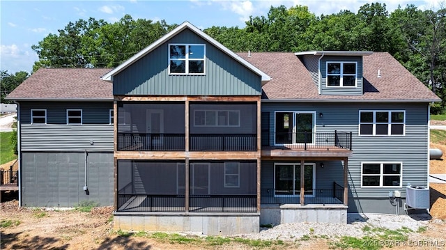 back of property featuring a balcony, central air condition unit, and a shingled roof