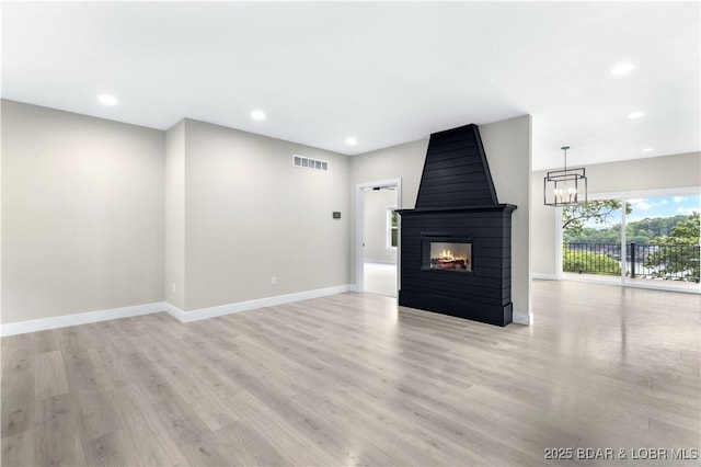 unfurnished living room featuring recessed lighting, a multi sided fireplace, visible vents, baseboards, and light wood finished floors