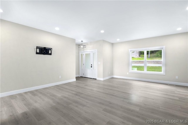 spare room with recessed lighting, wood finished floors, and baseboards