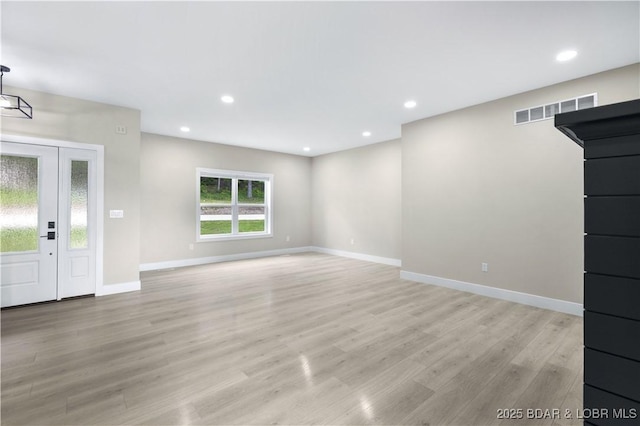 unfurnished living room featuring light wood-type flooring, baseboards, visible vents, and recessed lighting