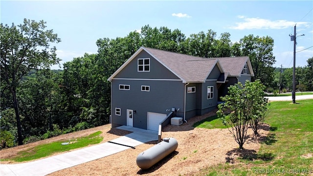 view of front facade featuring roof with shingles, an attached garage, and a front lawn